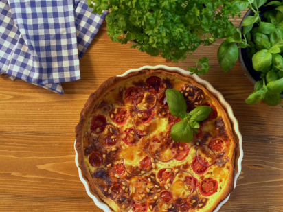 Das Bild zeigt eine Tomaten-Quiche mit Basilikum und mit Schärdinger CremiG